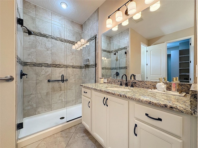 bathroom featuring tile patterned flooring, vanity, and an enclosed shower