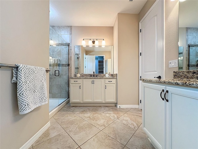 bathroom featuring tile patterned flooring, an enclosed shower, and vanity