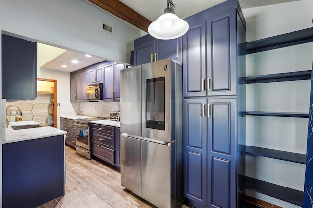 kitchen featuring appliances with stainless steel finishes, sink, backsplash, hanging light fixtures, and light stone countertops