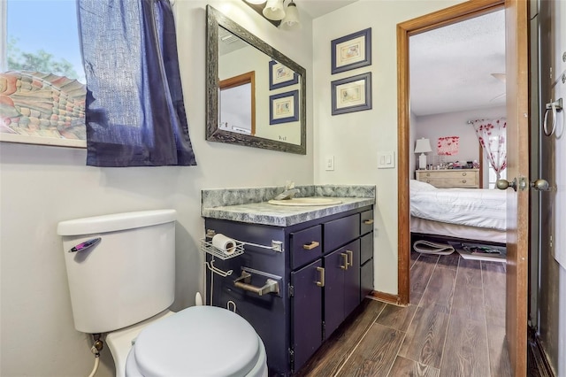 bathroom featuring vanity, hardwood / wood-style floors, and toilet