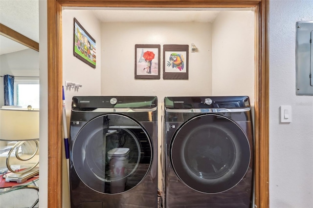 laundry room featuring electric panel and washer and clothes dryer