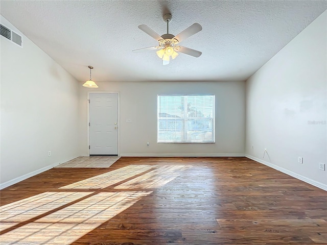 unfurnished room featuring ceiling fan, wood-type flooring, and a textured ceiling