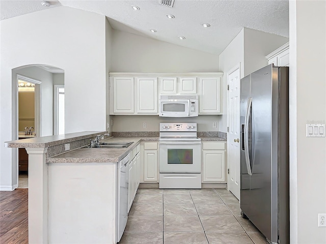 kitchen featuring white appliances, kitchen peninsula, sink, and white cabinets