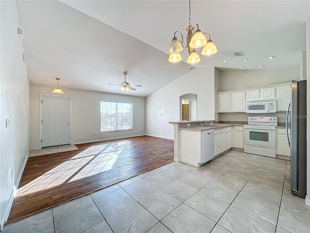 kitchen featuring light tile patterned flooring, decorative light fixtures, white cabinets, kitchen peninsula, and white appliances