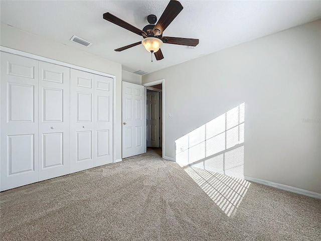 unfurnished bedroom with light carpet, ceiling fan, and a closet