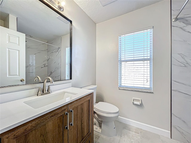 bathroom with vanity, a tile shower, a textured ceiling, and toilet