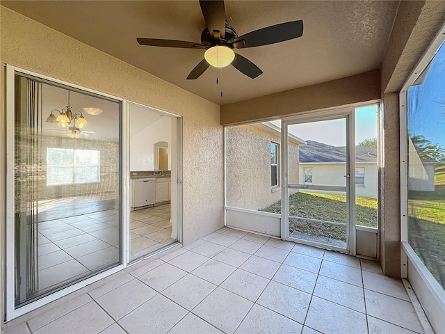 unfurnished sunroom featuring a mountain view and ceiling fan with notable chandelier