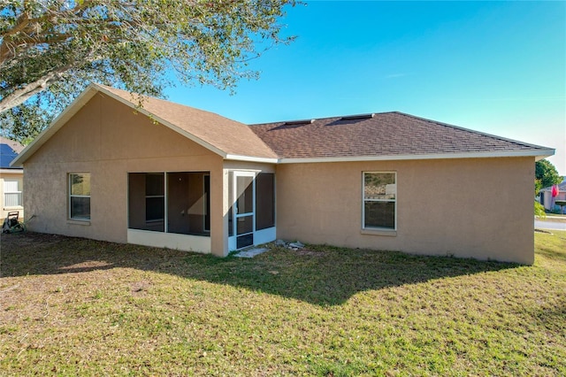 rear view of property with a yard and a sunroom