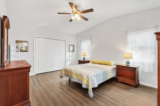 bedroom featuring lofted ceiling, hardwood / wood-style flooring, a closet, and ceiling fan