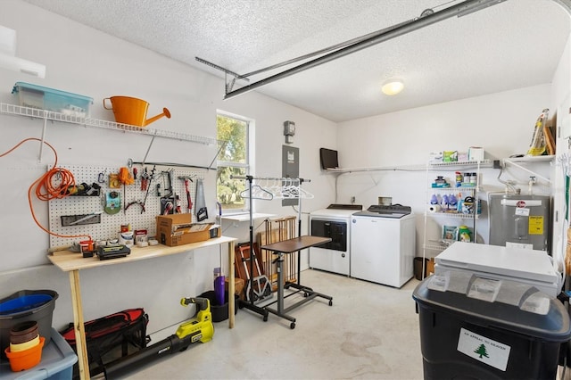 interior space featuring a workshop area, electric panel, electric water heater, a textured ceiling, and washing machine and clothes dryer