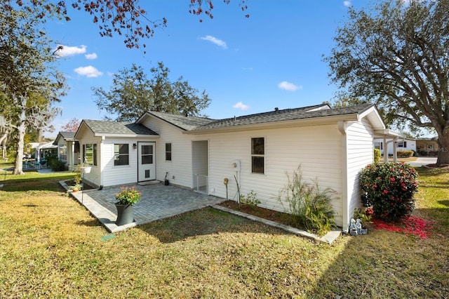 rear view of house with a yard and a patio