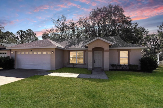 single story home with a garage and a yard