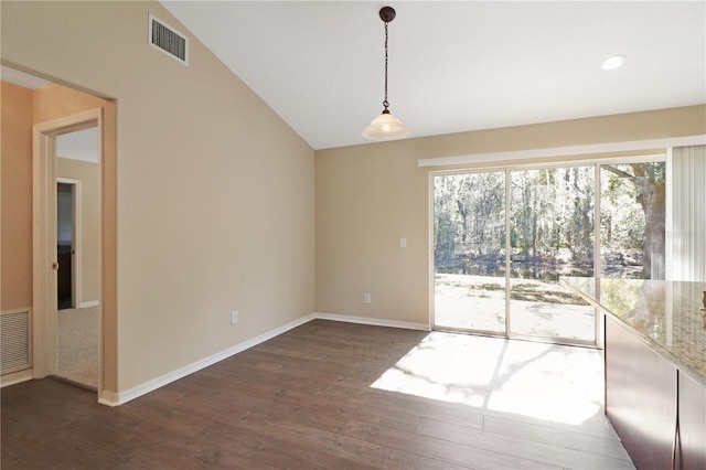 unfurnished dining area with dark wood-type flooring and vaulted ceiling