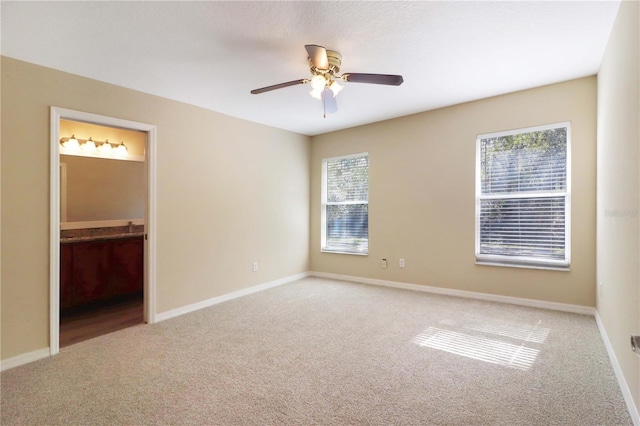 unfurnished bedroom with carpet floors, ceiling fan, and ensuite bathroom