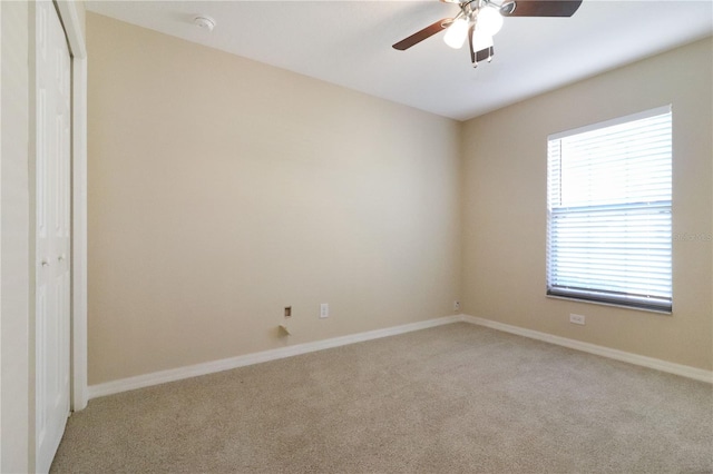 spare room with light colored carpet and ceiling fan