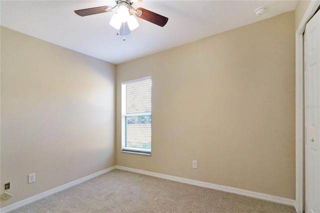 carpeted spare room featuring ceiling fan