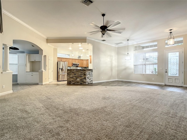 unfurnished living room with decorative columns, crown molding, light carpet, and ceiling fan