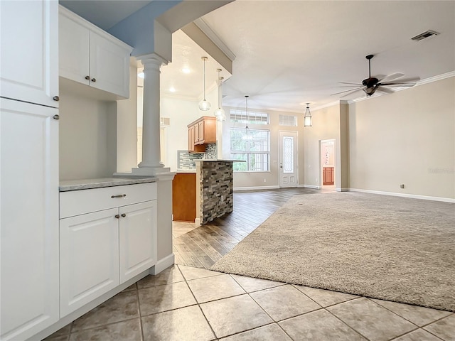 kitchen featuring white cabinetry, crown molding, ceiling fan, and ornate columns