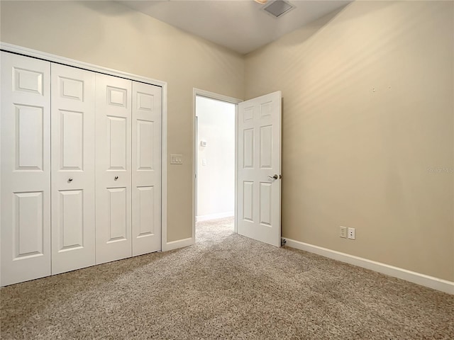 unfurnished bedroom featuring carpet floors and a closet