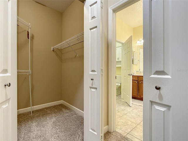 walk in closet featuring light tile patterned flooring