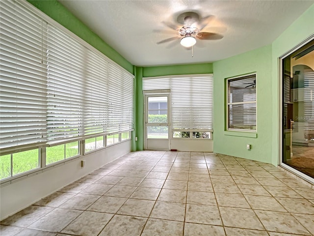 unfurnished sunroom featuring ceiling fan