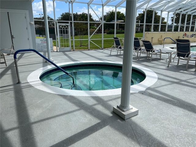 view of pool with an in ground hot tub, a patio, and glass enclosure