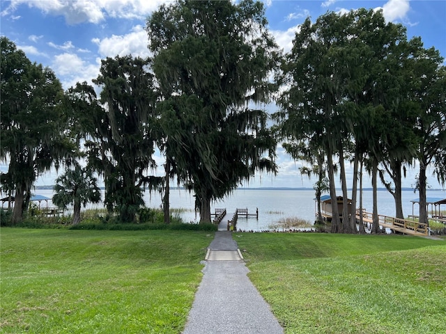 dock area with a water view and a yard