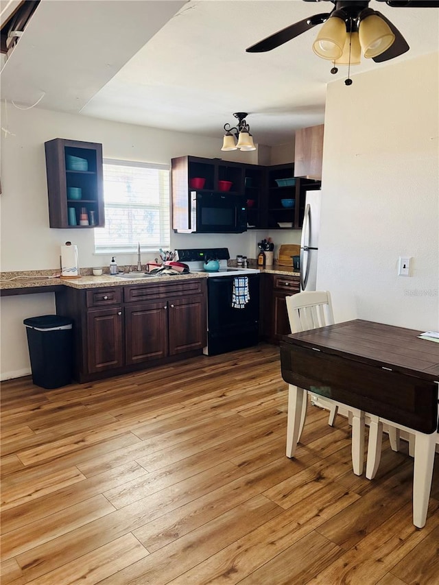 kitchen featuring sink, ceiling fan, dark brown cabinetry, black appliances, and light wood-type flooring