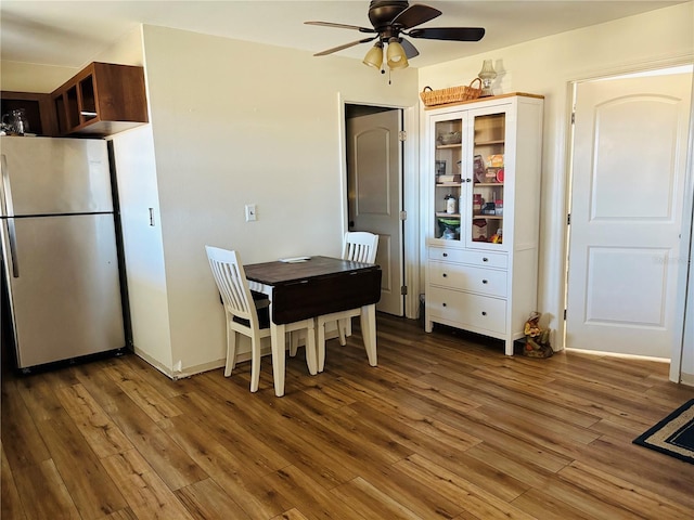 dining area with dark wood-type flooring and ceiling fan