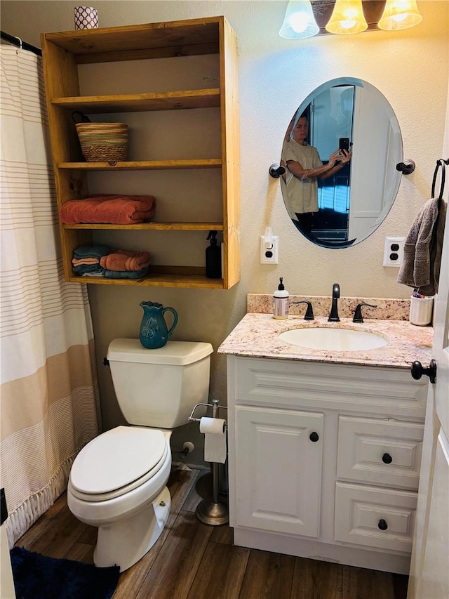 bathroom featuring wood-type flooring, vanity, and toilet