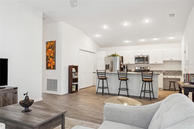 living room with lofted ceiling and light wood-type flooring