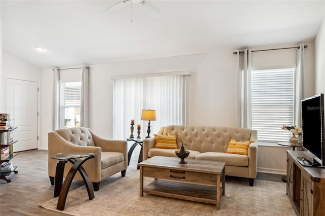 living room featuring vaulted ceiling, light hardwood / wood-style floors, and ceiling fan