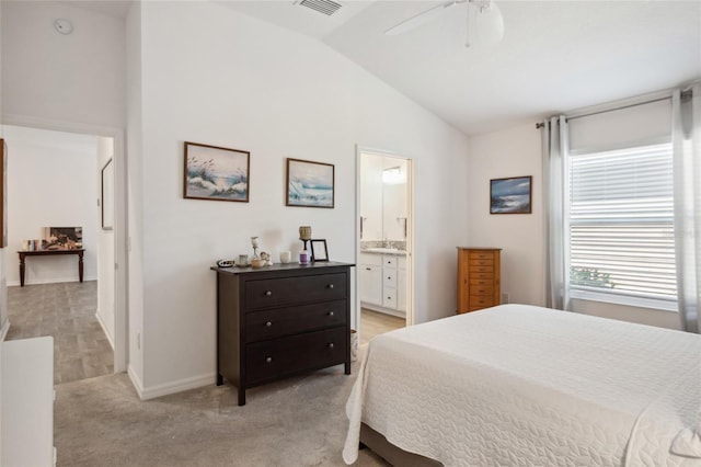 bedroom featuring lofted ceiling, connected bathroom, light carpet, and ceiling fan