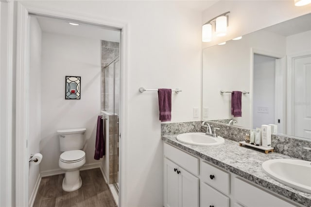 bathroom featuring vanity, hardwood / wood-style floors, an enclosed shower, and toilet