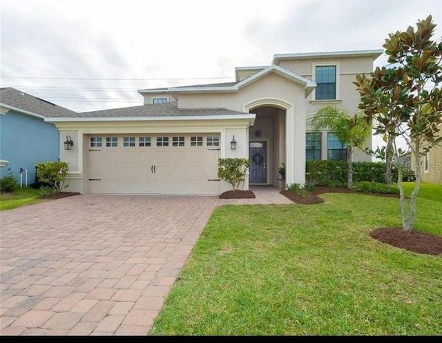 view of front of home with a garage and a front lawn