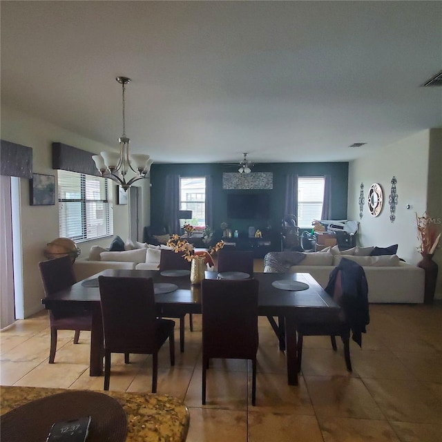 dining area with an inviting chandelier, tile patterned floors, and a healthy amount of sunlight