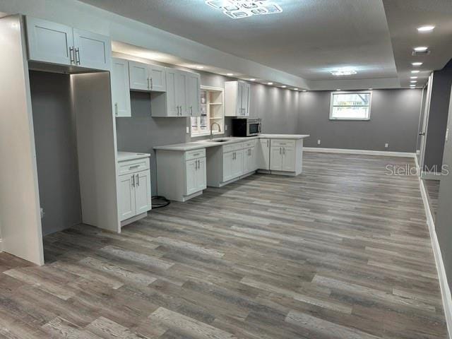 kitchen featuring sink, hardwood / wood-style floors, and white cabinets