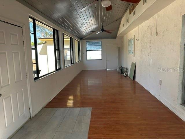 hall featuring lofted ceiling, wood-type flooring, and wooden ceiling