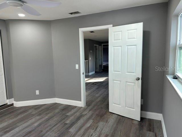 empty room featuring dark hardwood / wood-style floors and ceiling fan