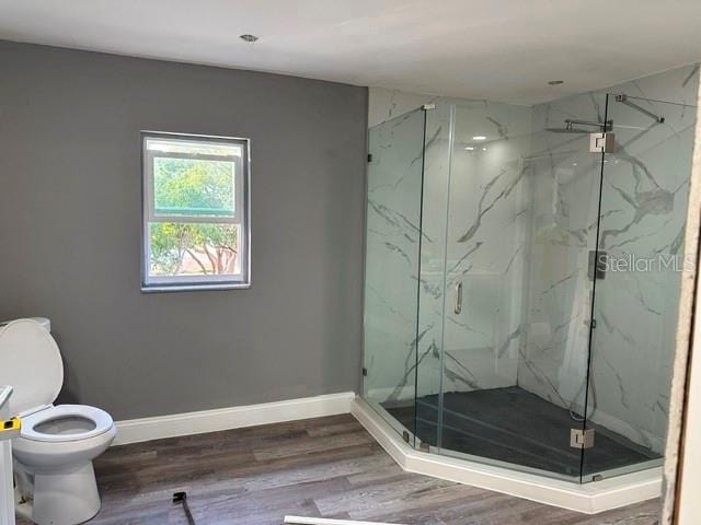 bathroom with an enclosed shower, hardwood / wood-style floors, and toilet