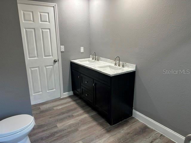 bathroom with vanity, toilet, and wood-type flooring