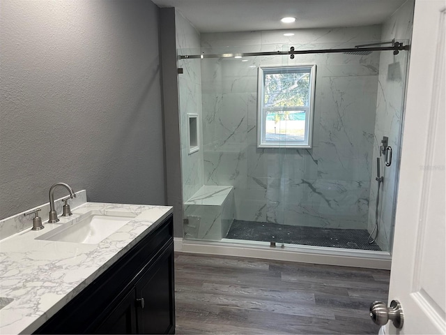 bathroom with a shower with door, vanity, and wood-type flooring