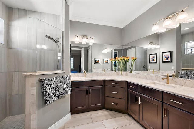 bathroom with crown molding, tiled shower, vanity, and tile patterned flooring