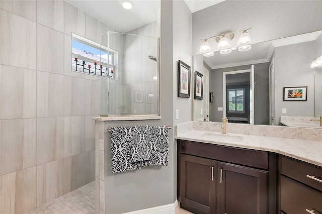 bathroom featuring vanity, ornamental molding, and a tile shower