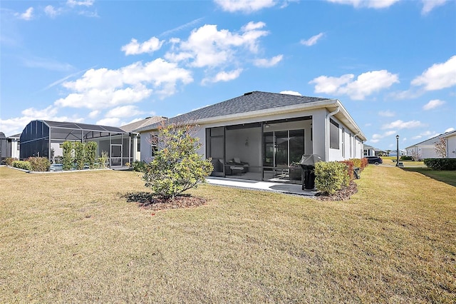 rear view of property featuring a patio area, a lawn, and glass enclosure