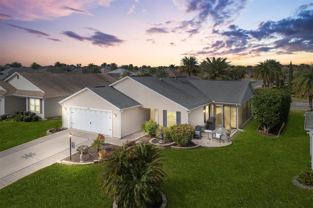 ranch-style house with a garage and a lawn