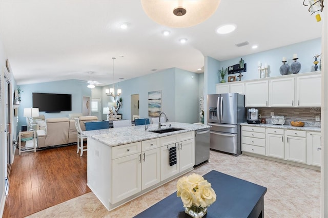 kitchen featuring white cabinetry, sink, decorative light fixtures, and appliances with stainless steel finishes