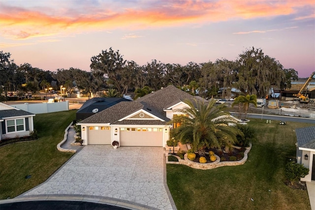 4515 Biggs Pl, The Villages, FL 32163 - view of front of home with decorative driveway, an attached garage, and a front lawn