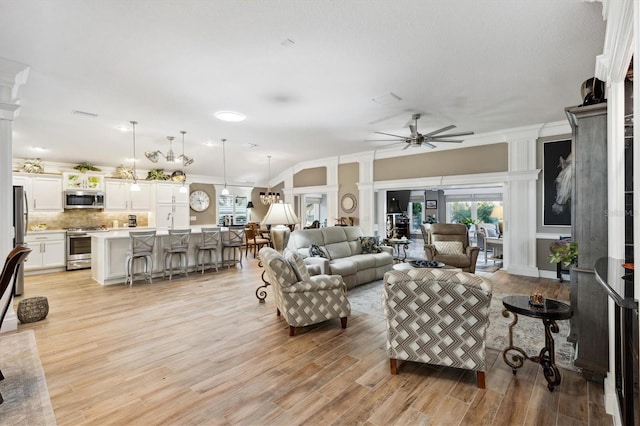 4515 Biggs Pl, The Villages, FL 32163 - living room with crown molding, ceiling fan, decorative columns, and light wood-type flooring