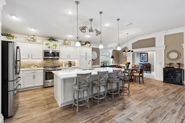 4515 Biggs Pl, The Villages, FL 32163 - kitchen with appliances with stainless steel finishes, a sink, light countertops, an inviting chandelier, and ornamental molding